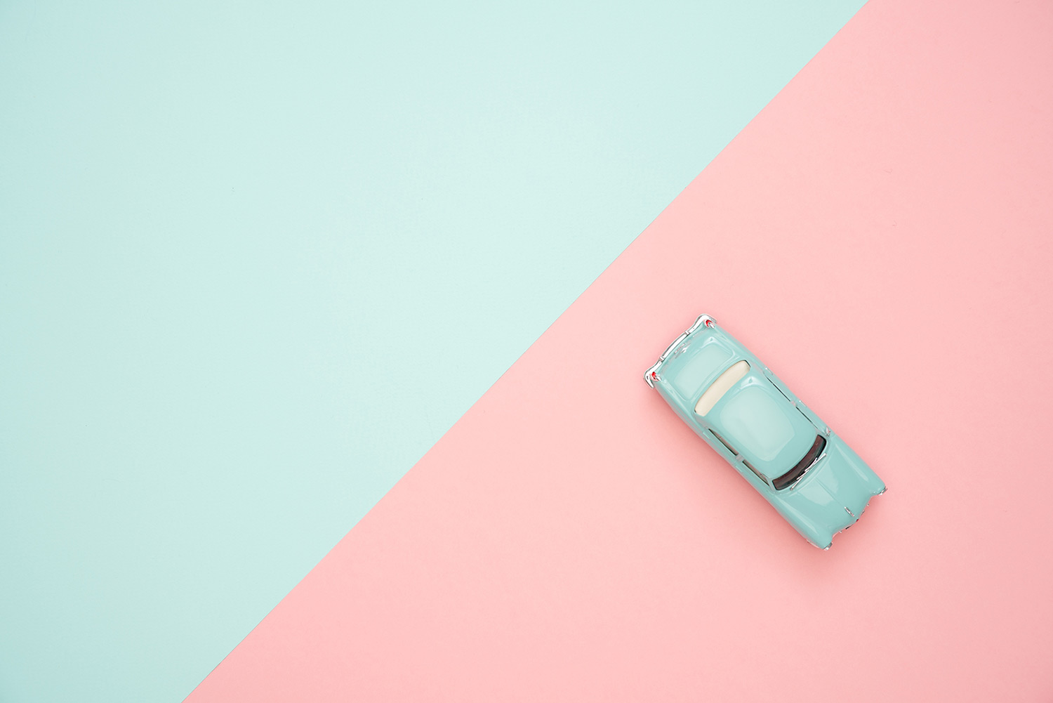 A pink and blue background with a toy car